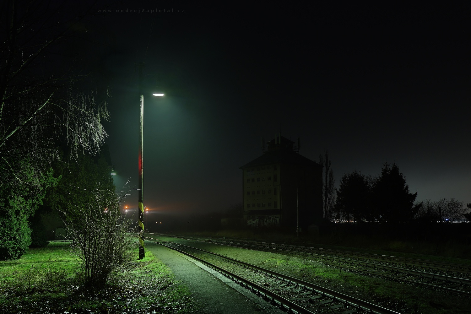 Pod lampou na nádraží (Na fotografii:  (Fotografie venkova) vlak, noc, elektřina, stromy)